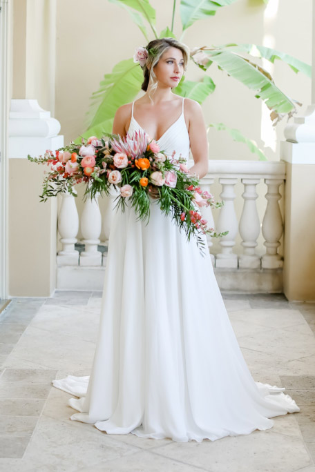 Woman wearing bridal gown holding flowers - Let Us Help You